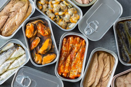 Photo for Assortment of different canned preserved fish and seafood in tin cans ready for tinned fish date night. Cheap and lowbrow food during economic crisis and inflation - Royalty Free Image