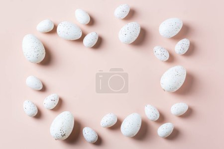 Téléchargez les photos : Joyeux cadre de Pâques avec des œufs dorés, blancs, en pointillés noirs et rayés sur un fond rose. Vue de dessus, plan plat, espace de copie. Carte de vœux de Pâques moderne - en image libre de droit