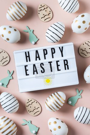 Téléchargez les photos : Joyeux cadre de Pâques avec des œufs dorés, blancs, en pointillés noirs et rayés sur un fond rose. Vue de dessus, plan plat. Carte de vœux de Pâques moderne - en image libre de droit