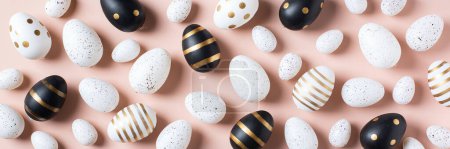 Téléchargez les photos : Joyeux cadre de Pâques avec des œufs dorés, blancs, en pointillés noirs et rayés sur un fond rose. Vue de dessus, plan plat. Carte de vœux de Pâques moderne, bannière - en image libre de droit