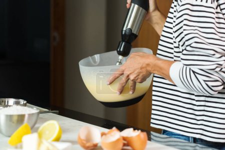 Foto de Woman kneading the dough while cooking apple pie in the modern kitchen - Imagen libre de derechos