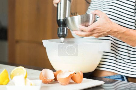 Photo for Woman kneading the dough while cooking apple pie in the modern kitchen - Royalty Free Image