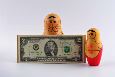 Photo for Russian doll with dollars inside isolated on white background.Matryoshka dolls colorful piggy bundle of money. - Royalty Free Image