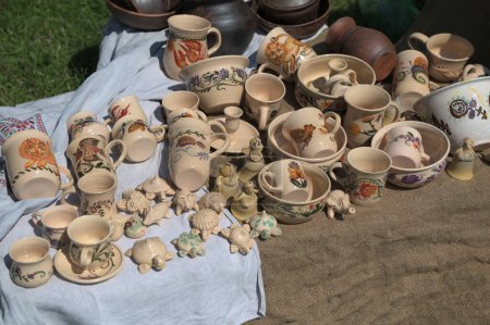 Téléchargez les photos : Lviv, Ukraine. 7 avril 2024.Étagères pleines de produits céramiques faits à la main .tasses, boules et jouets en céramique de couleur clair.Journée européenne de l'artisanat en Ukraine. - en image libre de droit
