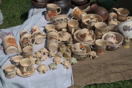 Téléchargez les photos : Lviv, Ukraine. 7 avril 2024.Étagères pleines de produits céramiques faits à la main .tasses, boules et jouets en céramique de couleur clair.Journée européenne de l'artisanat en Ukraine. - en image libre de droit