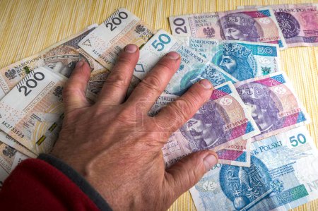 Il y a beaucoup de copies de papier-monnaie polonais avec la main en bois d'une idole sur eux.L'amour excessif de l'argent.Le concept de la crise financière.