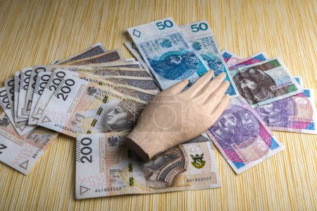 Il y a beaucoup de copies de papier-monnaie polonais avec la main en bois d'une idole sur eux.L'amour excessif de l'argent.Le concept de la crise financière.