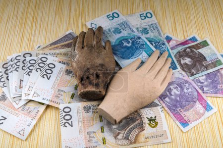 Hay muchas copias de papel moneda polaco con la mano de madera de un ídolo en ellos.El amor excesivo de dinero.El concepto de la crisis financiera.