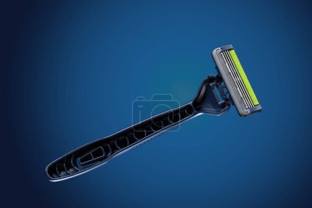 Photo for Razor with three blades on a dark blue background. Nobody. High angle studio shot. - Royalty Free Image