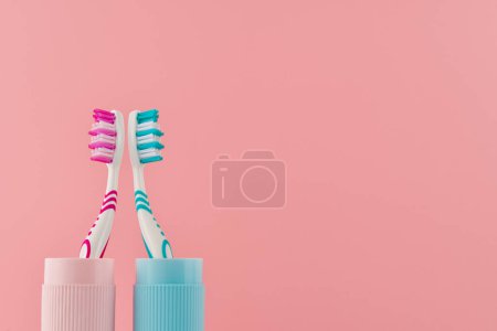 Téléchargez les photos : Deux brosses à dents dans un étui de voyage sur un fond rose à partir d'une vue à angle bas de l'espace de copie. Plan studio. - en image libre de droit