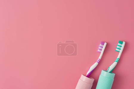 Téléchargez les photos : Deux brosses à dents dans un étui sur fond rose avec espace de copie. Vue du dessus. - en image libre de droit