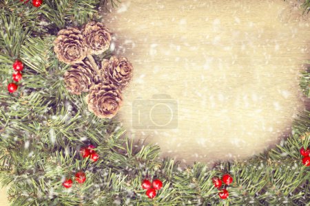 Foto de Guirnalda de Navidad colgando de la puerta de madera con nieve cayendo - Imagen libre de derechos