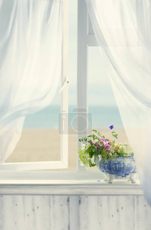 Foto de Ventana abierta junto al mar con cortinas onduladas y maceta de flores - Imagen libre de derechos