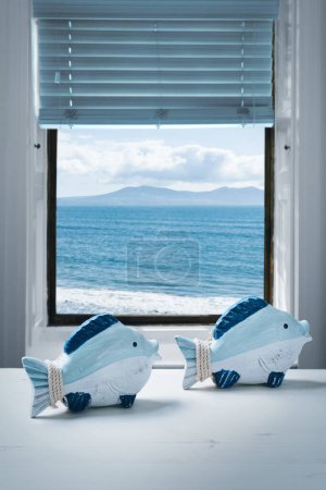 Téléchargez les photos : Deux ornements de poissons assis dans la fenêtre - en image libre de droit