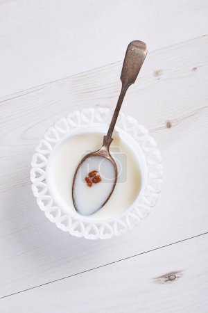 Foto de Cuenco de cereales con tres piezas restantes en leche con cuchara - Imagen libre de derechos