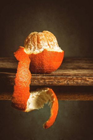 Photo for Orange half peeled on rustic table - Royalty Free Image