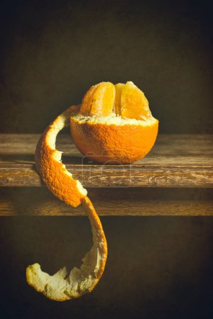 Téléchargez les photos : Orange demi pelé sur table rustique - en image libre de droit