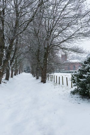 Foto de Camino de campo de invierno que conduce a un patio de la iglesia - Imagen libre de derechos
