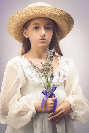 Foto de Chica joven con un sombrero de paja sosteniendo flores - Imagen libre de derechos