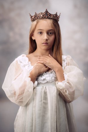 Young girl with arms crossed wearing a stately crown
