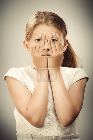 Foto de Imagen creativa de los ojos que aparecen a través de las manos de la joven - Imagen libre de derechos