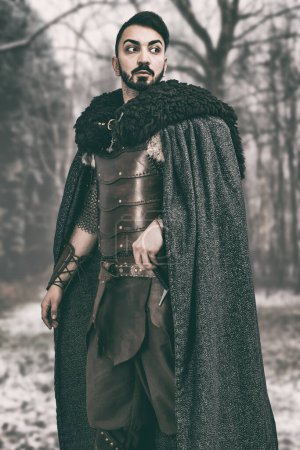 Man in medieval hand made leather costume wearing a robe 
