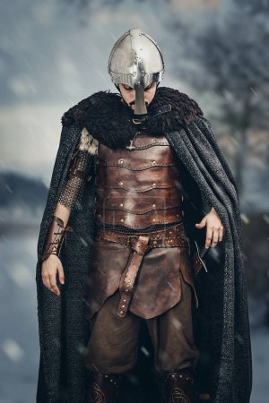 Man in medieval hand made leather costume wearing a helmet 