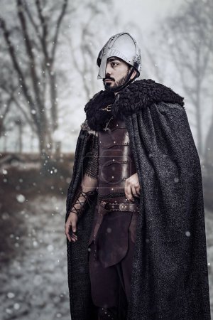 Man in medieval hand made leather costume wearing a helmet 