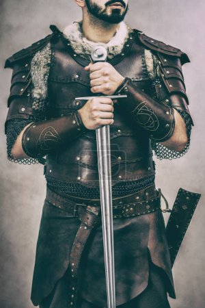 Foto de Hombre en traje de cuero hecho a mano medieval sosteniendo su espada - Imagen libre de derechos