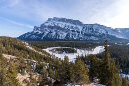 Banff National Park beautiful landscape. Panorama view Mount Rundle valley forest and frozen Bow River in winter. Hoodoos Viewpoint, Canadian Rockies.