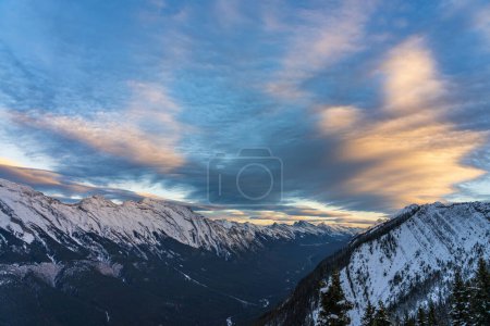 Snow capped Mount Rundle mountain range in beautiful dusk. Sky of red pink clouds in the background. Banff National Park in winter, Canadian Rockies. Beautiful nature scenery.