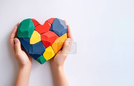 Foto de Childs manos sosteniendo un corazón sobre fondo blanco con copyspace. Día mundial de la conciencia del autismo. - Imagen libre de derechos