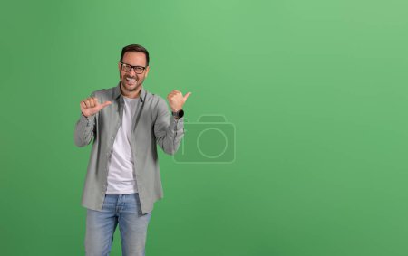 Porträt einer hübschen Verkäuferin, die fröhlich auf Kopierraum und Marketing auf grünem Hintergrund zeigt
