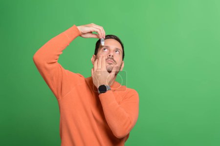 Porträt eines gutaussehenden Mannes, der sich um die Behandlung von Irritationen bewirbt, während er isoliert auf grünem Hintergrund steht