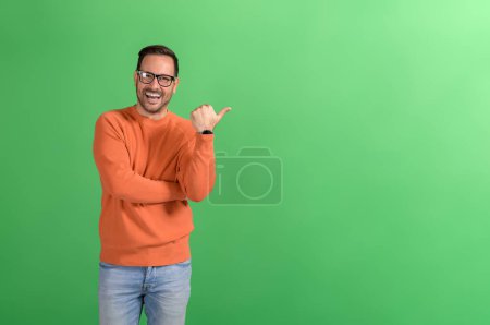 Porträt eines ekstatisch schönen Verkäufers, der auf Kopierraum und Marketing vor grünem Hintergrund zeigt