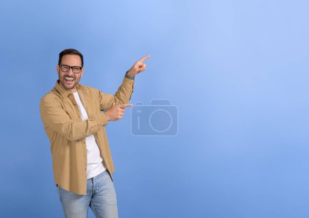 Porträt eines jungen glücklichen Verkäufers, der Kopierraum für die Vermarktung neuer Produkte auf blauem Hintergrund anstrebt