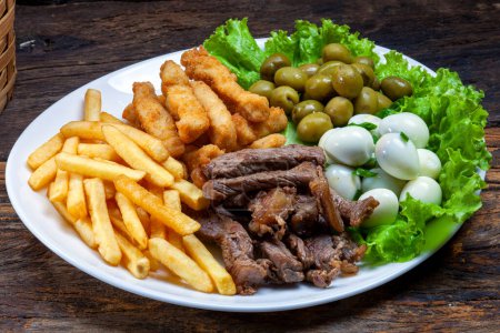 Photo for Snacks with fries, meat Picanha, quail egg, olives and breaded fish - Royalty Free Image
