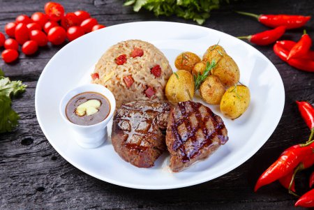 Foto de Roasted steak meat, potatoes and rice - Imagen libre de derechos