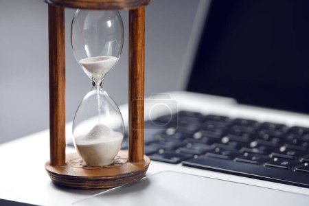 Foto de Reloj de arena como concepto de paso de tiempo para las empresas que estudian la fecha límite, urgencia y quedarse sin espacio de tiempo copyspace - Imagen libre de derechos