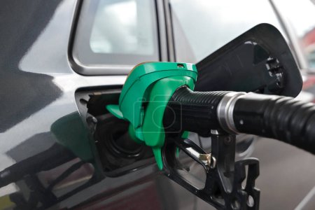 Fueling car with petrol pump at a gas station. Petrol station. Gasoline and oil products. Close up. Edit now