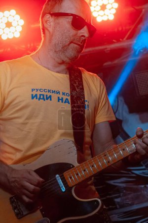 Téléchargez les photos : Vinnytsia, Ukraine - 28.05.2022 : Andriy Kudasov joue du blues en solo à la guitare Rittenhouse, guitariste du groupe de rock Braty Hadiukiny sur scène au Royal Pub, performance en festival live, effet motion blur - en image libre de droit