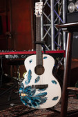 Vinnytsia, Ukraine - 03.12.2022: Yamaha acoustic guitar on stand, synthesizer on stage of Royal Pub, custom made instrument ready for rock group performance, shallow dof, high noise editorial image Stickers #698858002