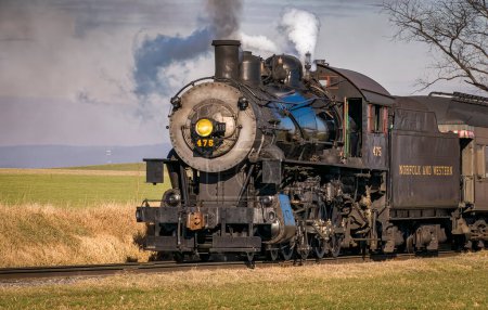 Foto de Ronks, Pennsylvania, December 30, 2022 - A Close Up View of a Classic Steam Passenger Train Approaching, Traveling Thru the Countryside, Blowing Smoke and Steam on a Winter Day - Imagen libre de derechos
