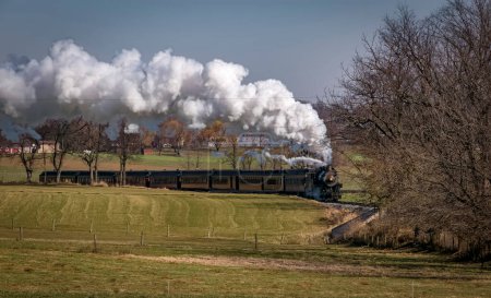 Foto de A View of An Antique Passenger Train Approaching, Blowing Smoke and Steam, on an Autumn Day - Imagen libre de derechos