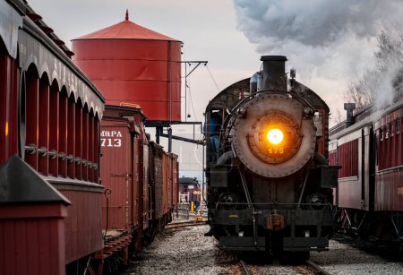 Foto de Strasburg, Pennsylvania, December 27, 2022 - A View of a Classic Steam Passenger Train Arriving into a Train Station Blowing Smoke and Steam, on a Winter Day - Imagen libre de derechos
