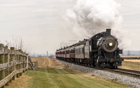 Foto de A View of a Classic Steam Passenger Train Approaching, Traveling Thru the Countryside, on a Winter Day - Imagen libre de derechos