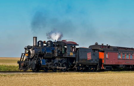 Foto de Ronks, Pennsylvania, October 22, 2022 - A View of a Classic Steam Passenger Train Passing By Blowing Smoke and Steam on a Sunny Day - Imagen libre de derechos