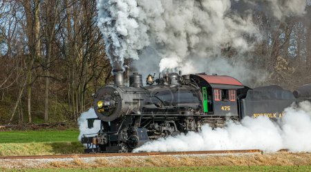 Foto de Ronks, Pennsylvania, December 4, 2022 - A View of a Classic Steam Passenger Train, Blowing Lots of Smoke and Steam, While Traveling in the Countryside on an Autumn Day - Imagen libre de derechos