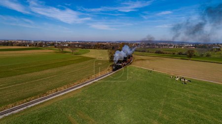 Photo for An Aerial View of a Steam Freight Train Approaching Around a Curve Blowing Smoke on a Sunny Autumn Day - Royalty Free Image
