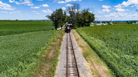 Photo for A Head on Drone View of a Steam Passenger Train Approaching on a single Track on a Sunny Summer day - Royalty Free Image